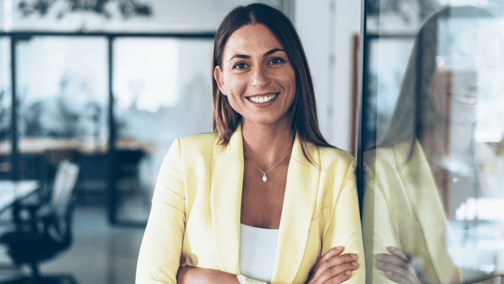 Mulher sorridente de blazer amarelo em escritório